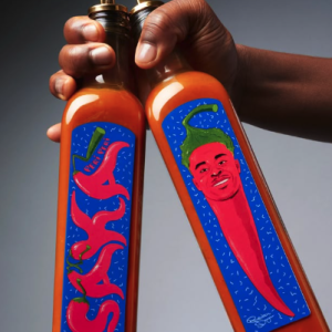 two hot sauce bottles being held