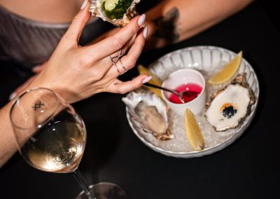 Oyster being held and wine